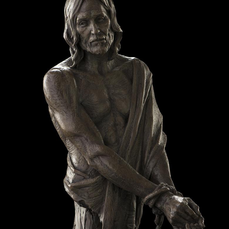 A bronze and sandstone sculpture by Benjamin Ray Hammond depicting the suffering Christ.